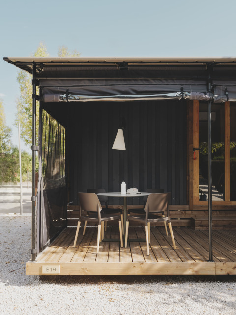 Buiten terras bij TINY HOME FAMILY, Wecamp Jávea, Spanje, met tafel, vier stoelen en houten vloer.