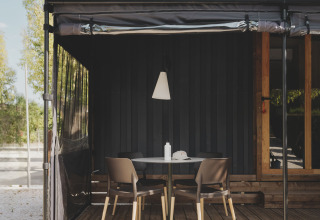 Buiten terras bij TINY HOME FAMILY, Wecamp Jávea, Spanje, met tafel, vier stoelen en houten vloer.