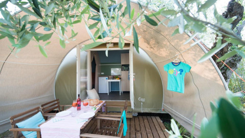 Coco Suite safari-tent bij Weekend Glamping Resort in Italië, met terras, eettafel en gezellige uitstraling.