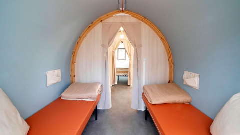 Binnenzicht van de Coco Suite safaritent met twee aparte bedden bij Weekend Glamping Resort in Italië.