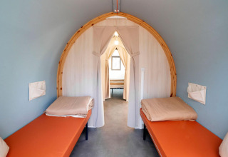 Binnenzicht van de Coco Suite safaritent met twee aparte bedden bij Weekend Glamping Resort in Italië.