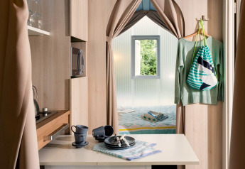 Interno della tenda safari Coco Suite con angolo cottura, zona pranzo e letto al Weekend Glamping Resort in Italia.