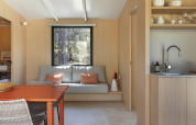 Lichte, moderne zithoek in chalet MOBIL HOME FAMILY bij Wecamp Jávea, Spanje, met minimalistisch design.