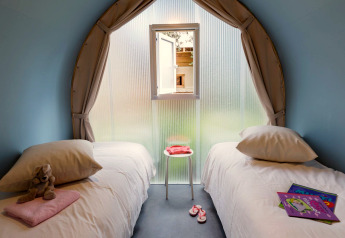 Interno della tenda safari Coco Suite al Weekend Glamping Resort in Italia, con due letti singoli.