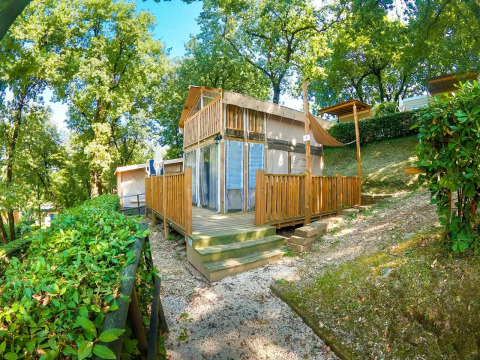 Safari tent Air Lodge met houten terras, omringd door bomen bij Weekend Glamping Resort in Italië.