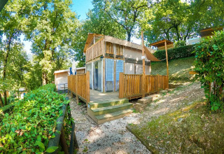 Safari tent Air Lodge met houten terras, omringd door bomen bij Weekend Glamping Resort in Italië.