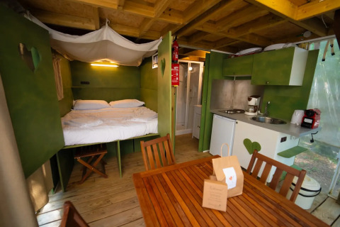 Binnenaanzicht van de safaritent 'Air lodge' bij Weekend Glamping Resort, Italië, met bed en keuken.