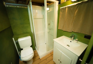 Badkamer in de Air Lodge safaritent op Weekend Glamping Resort in Italië met douche en groene muren.