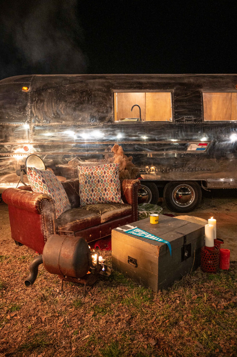 Gezellige zithoek met sofa, vuurkorf en kaarsen voor een Airstream tiny house bij Chianti Glamping Resort.