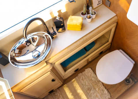 Modern badkamer in de Airstream tiny house op Chianti Glamping Resort met ronde wastafel en handdoeken.