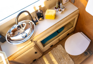 Modern badkamer in de Airstream tiny house op Chianti Glamping Resort met ronde wastafel en handdoeken.