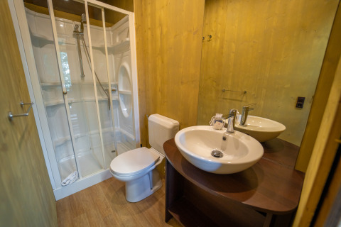 Badezimmer mit Dusche, Toilette und Waschbecken im Lodge Tent Deluxe im Weekend Glamping Resort in Italien.