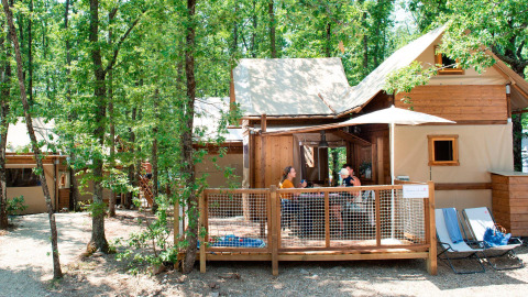 Zwei Personen sitzen auf der Terrasse eines Air Dreamer Safari-Zelts im Chianti Glamping Resort, Italien.