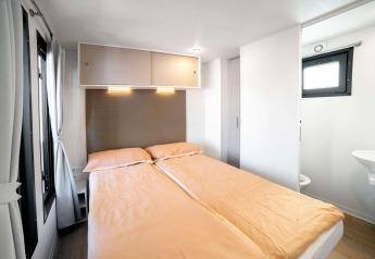 Dormitorio luminoso y moderno en una tiny house Cottage Next L del Chianti Glamping Resort, Italia.