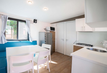 Cocina luminosa y moderna con comedor en la Cottage Next L del Chianti Glamping Resort, Italia.