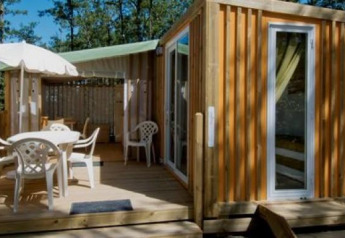 Vista exterior de la cabaña Cottage Clever en Chianti Glamping Resort, Italia, con terraza y naturaleza.