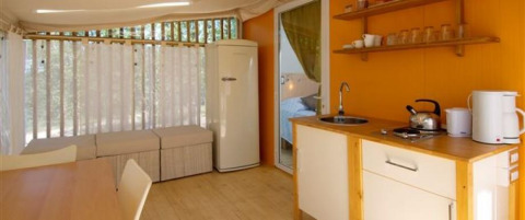 Interieur van Cottage Clever-lodge bij Chianti Glamping Resort in Italië met keuken en zithoek.