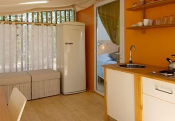 Interior del lodge Cottage Clever en Chianti Glamping Resort, Italia, con cocina y zona de estar.