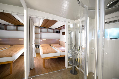 Moderne kamer met twee bedden en een badkamer in Cottage Clever bij Chianti Glamping Resort, Italië.