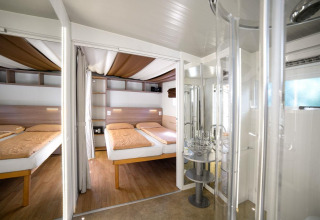 Moderne kamer met twee bedden en een badkamer in Cottage Clever bij Chianti Glamping Resort, Italië.