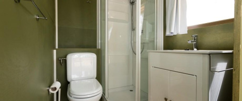 Modern bathroom with toilet, shower, and sink in Airlodge 1 at Chianti Glamping Resort, Italy.