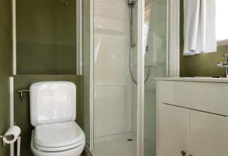 Modern bathroom with toilet, shower, and sink in Airlodge 1 at Chianti Glamping Resort, Italy.