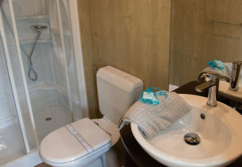 Bagno moderno con doccia, WC e lavandino nella sistemazione glamping Lodge Tent Deluxe.