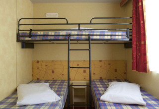 Chambre du Cottage Classic au Chianti Glamping Resort avec lits superposés et literie à carreaux.