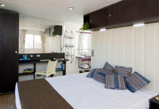 Binnenkant van de Cube Suite in Chianti Glamping Resort, Italië, met modern slaapgedeelte en bureau.