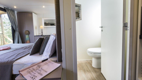 Cube Suite in Chianti Glamping Resort, Italië: gezellige slaapkamer met zicht op het moderne sanitair.