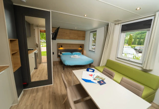 Interieur van Cube Suite XL chalet bij Lago Idro Glamping Boutique met bed, zithoek en grote ramen.