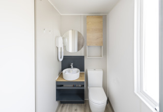 Moderne badkamer in Cube Suite XL van Lago Idro Glamping Boutique, met wasbak, spiegel en wc.