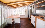 Knusse keuken en eetruimte in Cottage Clever, Lago Idro Glamping Boutique, met hout en licht interieur.