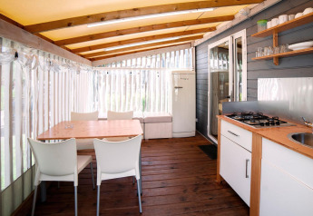 Acogedora cocina y comedor en Cottage Clever, Lago Idro Glamping Boutique, con detalles de madera y decoración clara.