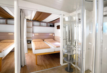 Interior moderno del chalet Cottage Clever en Lago Idro Glamping Boutique, Italia, con dos camas cómodas.