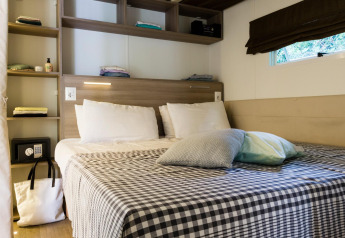 Dormitorio acogedor en Cottage Clever de Lago Idro Glamping Boutique, Italia, con cama doble y estanterías.