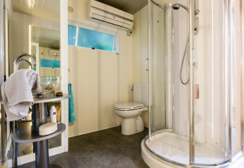 Baño moderno con ducha de cristal, inodoro y lavabo en Cottage Clever de Lago Idro Glamping Boutique, Italia.