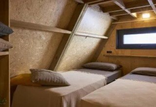 Twee enkele bedden in een sfeervolle houten kamer bij A Luxury, Chianti Glamping Resort, Italië.