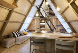 Binnenzicht op een luxe A-vormige lodge in het Chianti Glamping Resort, Italië, met een moderne inrichting.