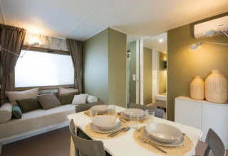 Intérieur moderne du lodge Cottage Next L Evo au Chianti Glamping Resort avec table à manger et canapé.