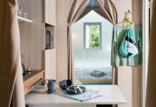 Vue intérieure d'une tente safari Coco Suite au Chianti Glamping Resort en Italie, avec cuisine et lit.