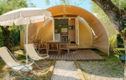 Safari-Zelt 'Coco Suite' im Chianti Glamping Resort Italien mit Terrasse, Stühlen und Sonnenschirm.