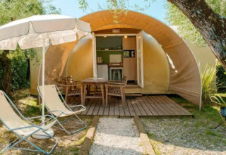 Tente safari Coco Suite au Chianti Glamping Resort en Italie, terrasse avec chaises longues et parasol.