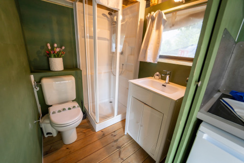 Moderne badkamer in Air Lodge, Lago Idro Glamping Boutique, Italië, met houten vloer, douche en lavabo.