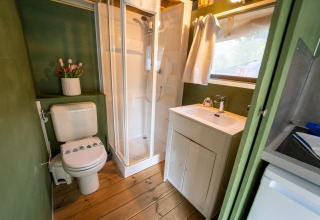 Moderne badkamer in Air Lodge, Lago Idro Glamping Boutique, Italië, met houten vloer, douche en lavabo.