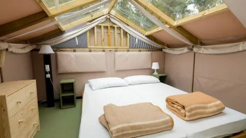 Slaapkamer in de Air Lodge van Lago Idro Glamping Boutique in Italië, met dubbel bed en dakvenster.