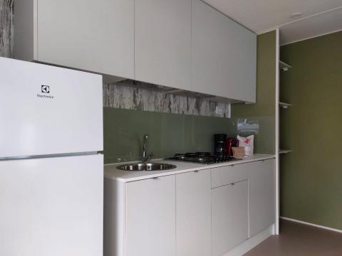 Moderne kitchenette in de Next XL Loggia-chalet bij Lago Idro Glamping Boutique in Italië met koelkast
