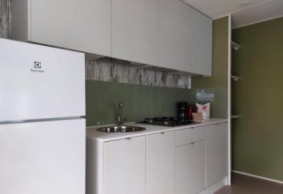 Moderne kitchenette in de Next XL Loggia-chalet bij Lago Idro Glamping Boutique in Italië met koelkast