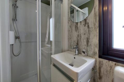 Moderne badkamer in de Next XL Loggia chalet bij Lago Idro Glamping Boutique in Italië, met douche en raam.
