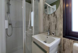 Moderne badkamer in de Next XL Loggia chalet bij Lago Idro Glamping Boutique in Italië, met douche en raam.